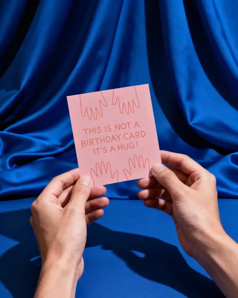 Minimalist Stylish Greeting Card Mockup In Hands With Draped Fabric Backdrop For Branding