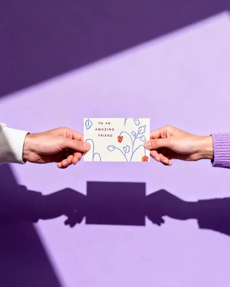 Hands Holding Horizontal Greeting Card Mockup On Vibrant Background For Design Showcase