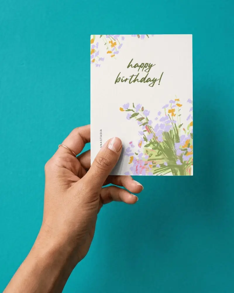 Hand Holding Blank Greeting Card Mockup On Solid Color Background For Design