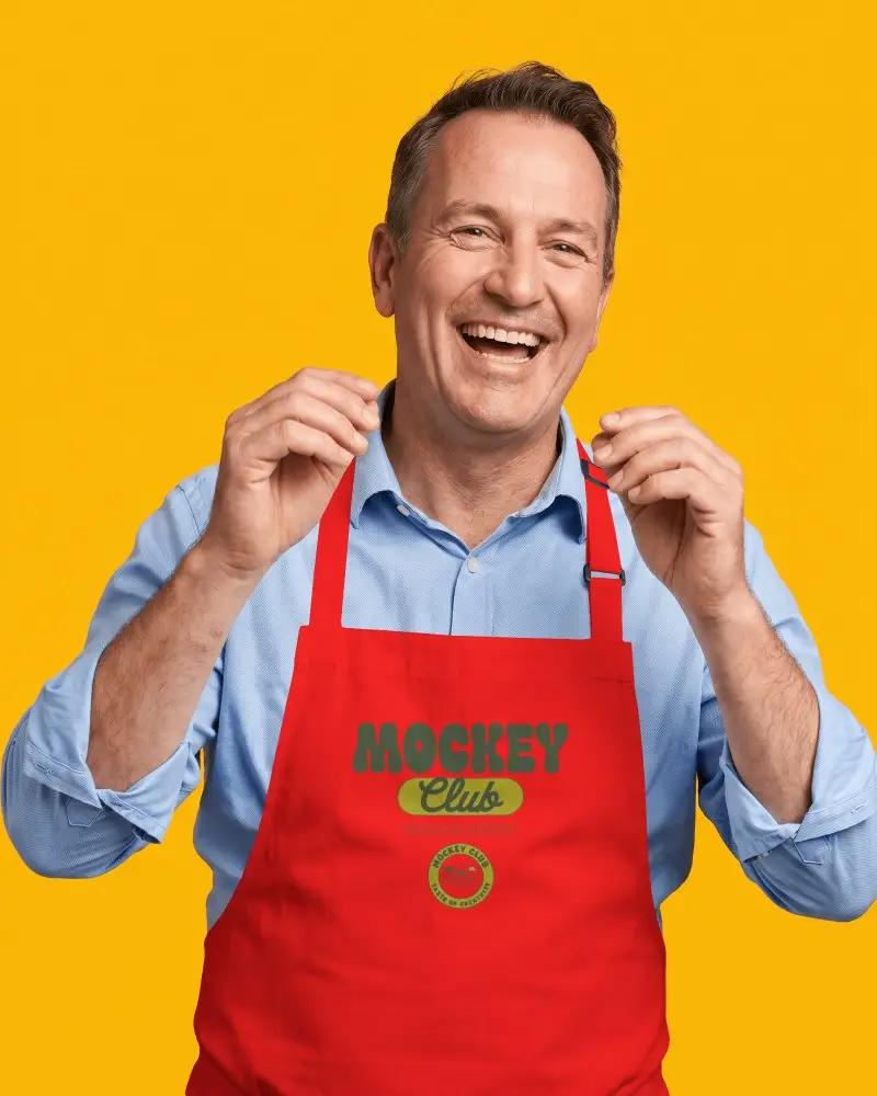 Cheerful Male Model Chef Apron Mockup On Bold Yellow Studio Background With Bright Smile