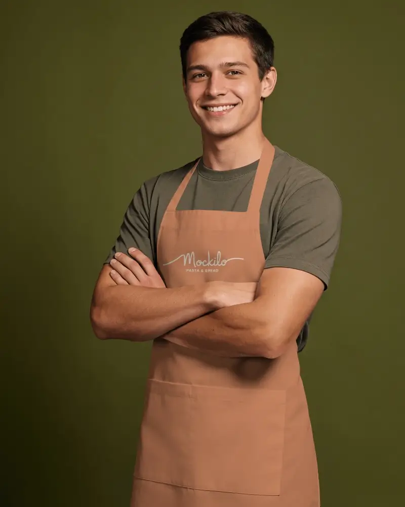 Smiling Male Chef Model Apron Mockup With Crossed Arms On Deep Olive Green Studio