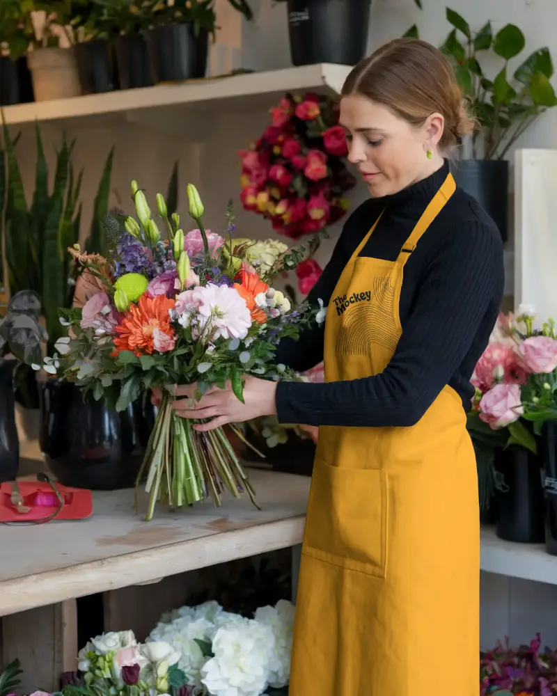 Professional Florist Wearing Durable Apron Mockup Arranging Beautiful Flower Bouquet In Shop