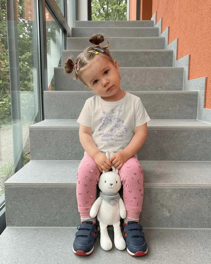 Baby Tee Mockup Toddler Girl Sitting On Gray Staircase Holding Plush Bunny Toy