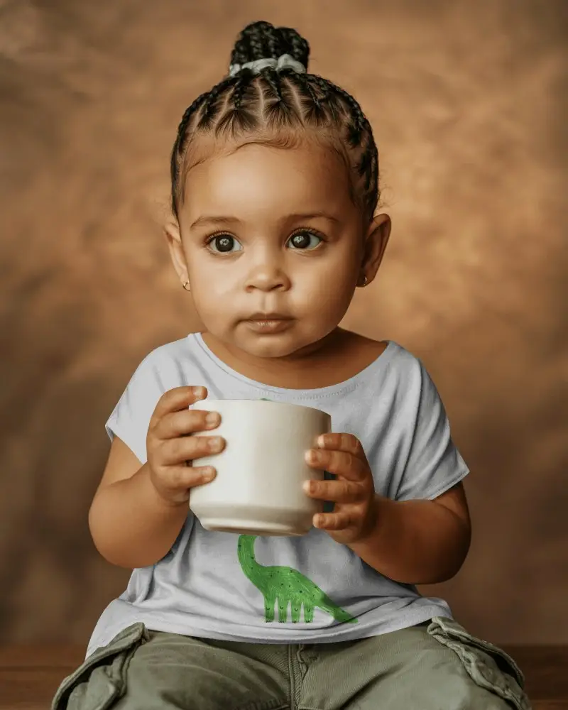 Adorable Baby Tee Mockup With Cup Held By Child For Custom Baby Clothing Designs