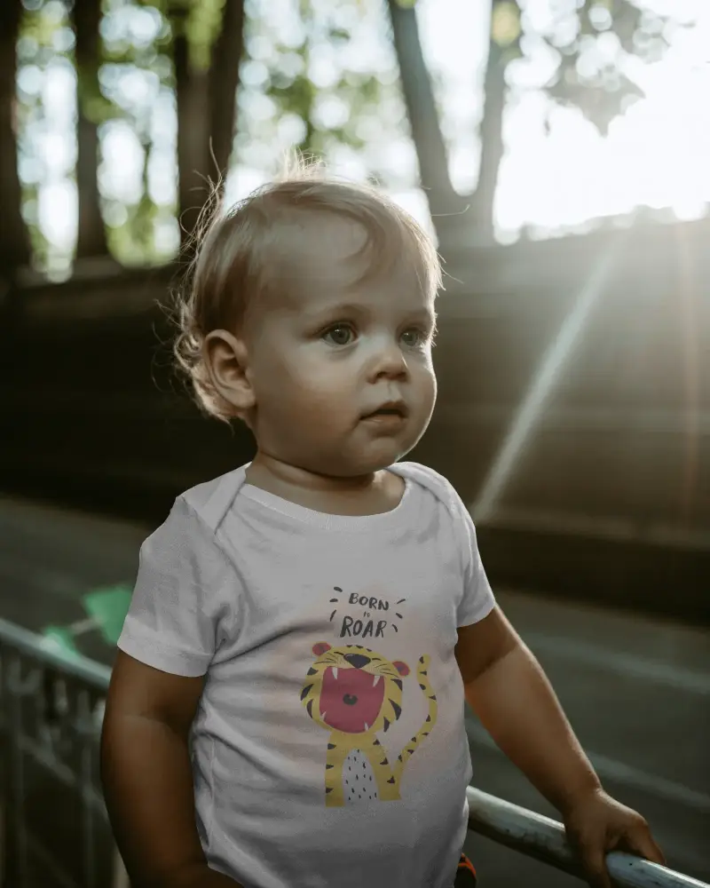 Sunlit Forest Path Baby Tee Mockup Toddler Standing By Railing Soft Light Through Trees Outdoor Scene