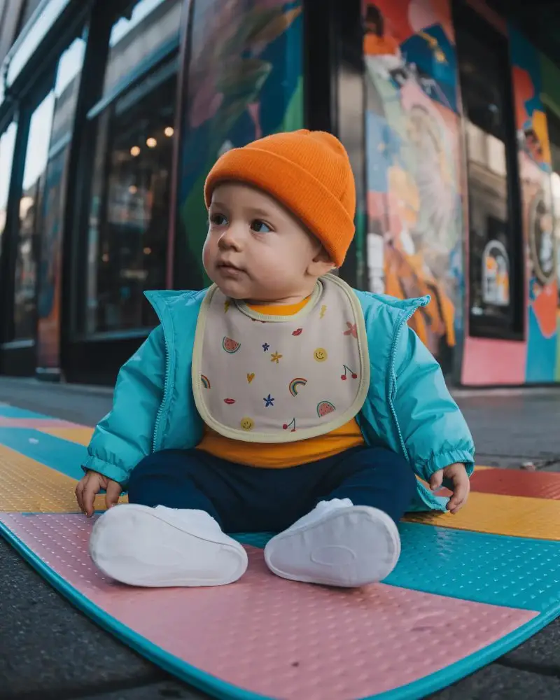 Infant Bib Mockup With Casual Baby Sitting On Playmat For Baby Products Promotion