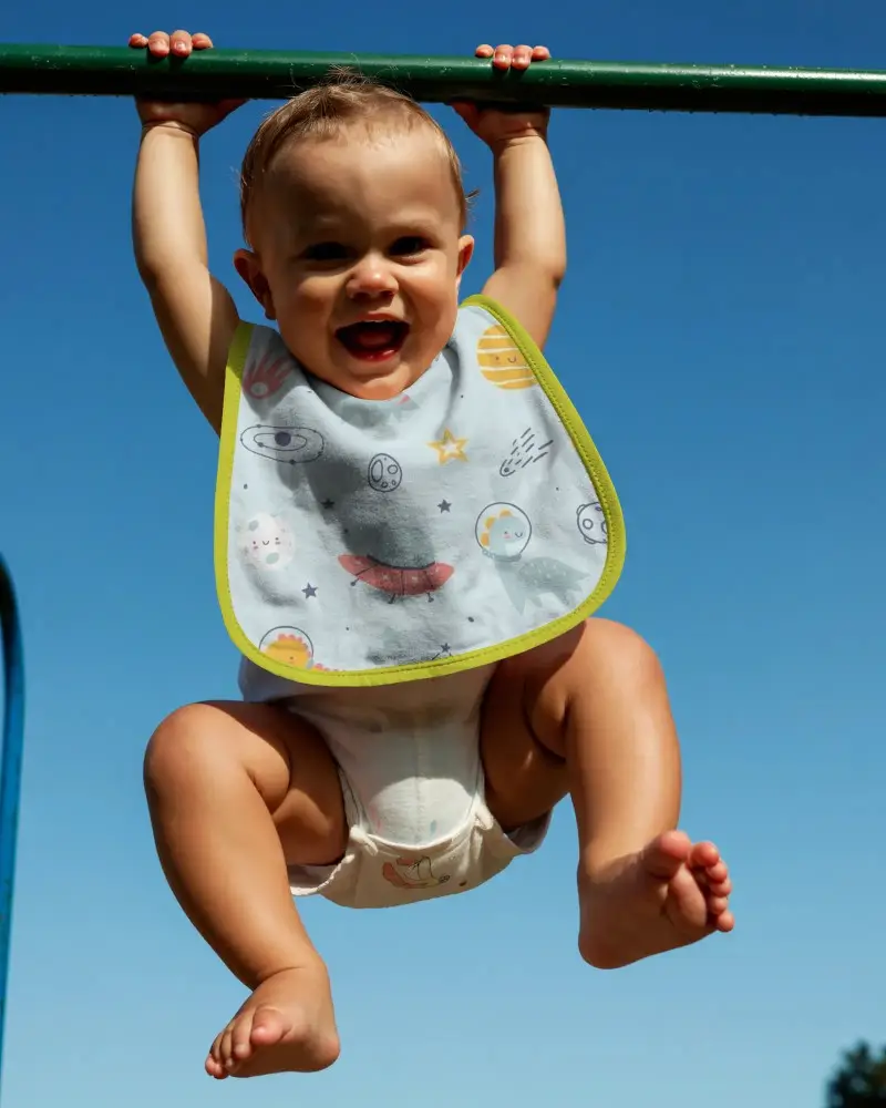 Happy Baby Hanging On Bar Wearing Soft Comfortable Bib Mockup Outdoor Playtime Fun