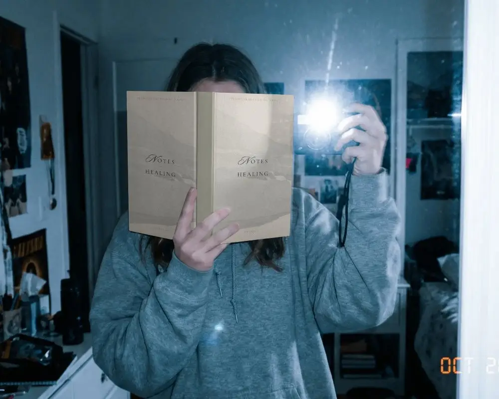 Reflective Interior Shot With Person Holding Book Mockup Cover Facing Camera Flash Enabled