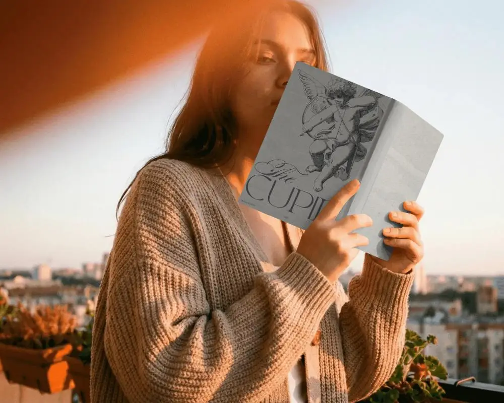Woman Reading Hardcover Book Outdoor Balcony Cityscape Background Sunset Light