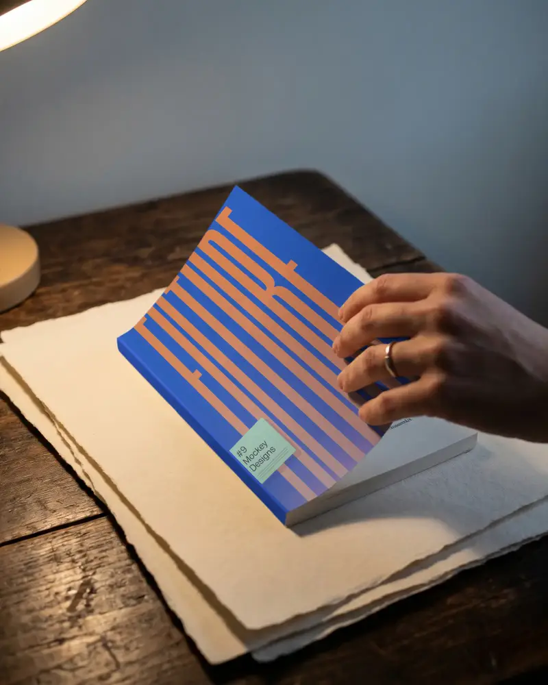 Hand Flipping Book Mockup Pages On Vintage Wooden Table With Warm Light Reading