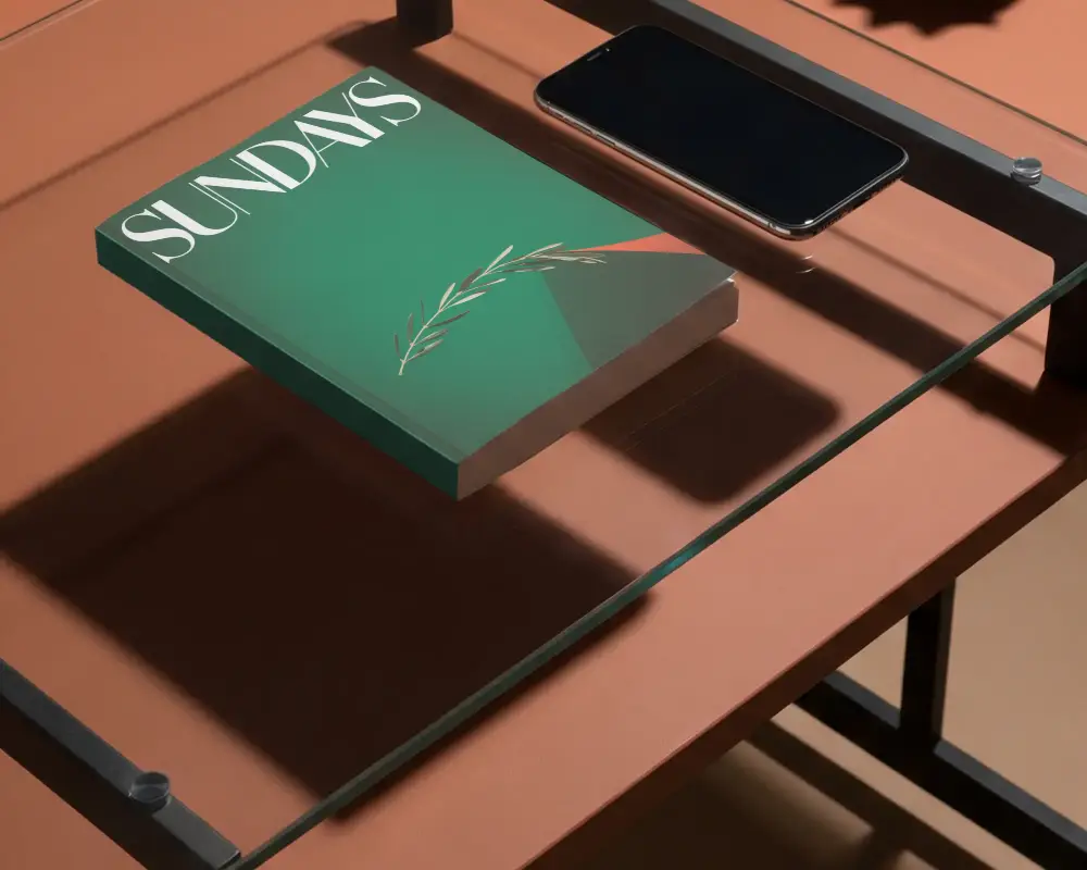 Blank Softcover Book Mockup On Minimalist Glass Table With Smartphone Nearby