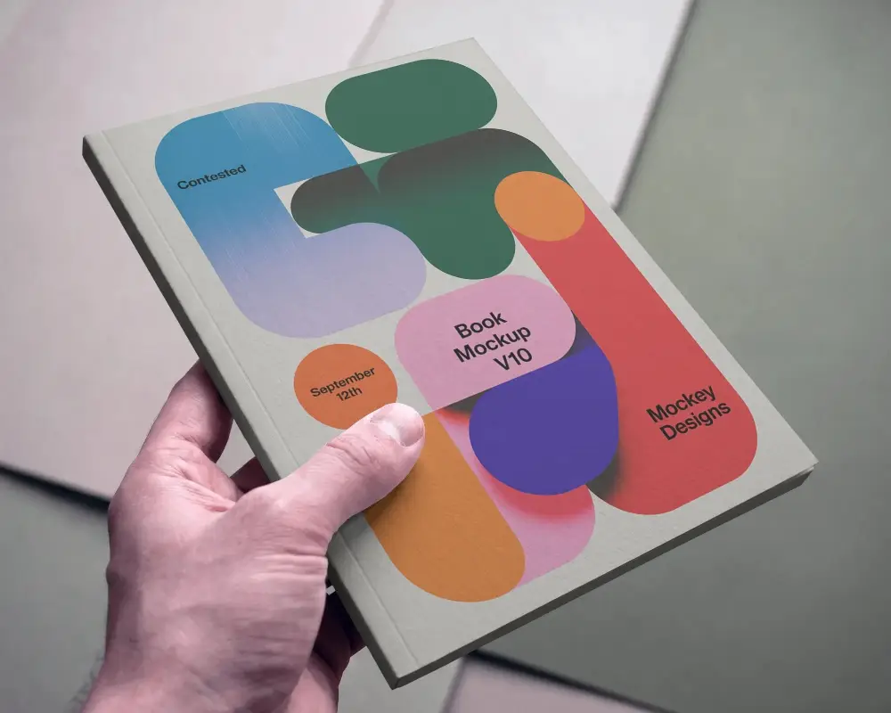 Realistic Closeup Of Hand Holding Hardcover Book Mockup On Geometric Background For Presentation