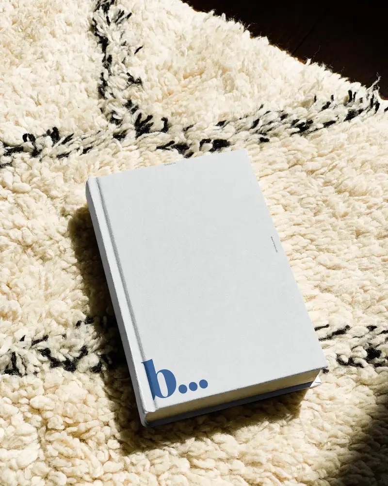 Hardcover Book Mockup Blank Cover Lying On Textured Cozy Rug In Natural Light