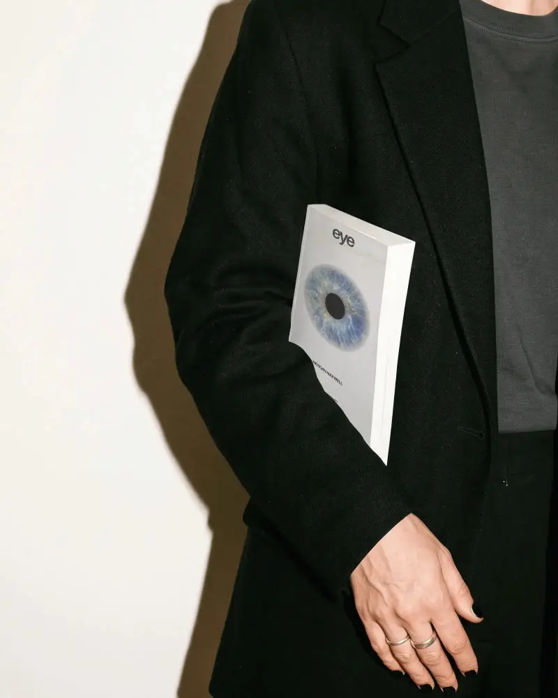Person Holding Blank Softcover Book Mockup Against Minimalist Background For Presentation