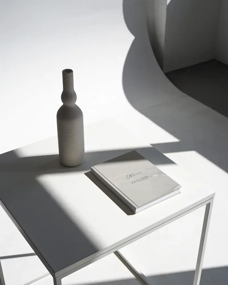 Hardcover Book Mockup Blank Cover Next To Textured Ceramic Vase On Well Lit Table