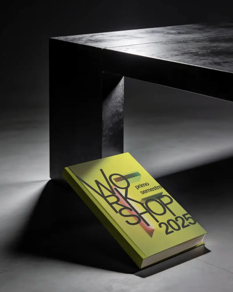 Simple Book Mockup Angled Against Table Leg In Dark Room With Focused Lighting