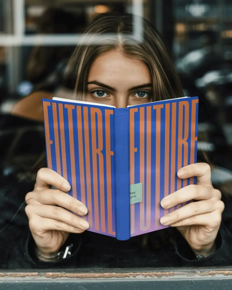 Woman Absorbed In A Book Holding Mockup Up Front Cover Creating Mystery And Interest