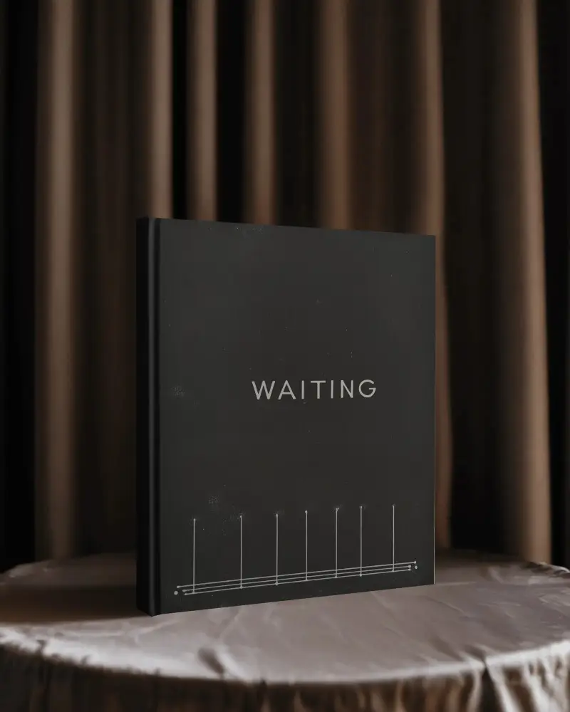 Hardcover Book Mockup Standing On Satin Covered Round Table Against Dark Curtain Backdrop Soft Dramatic Lighting With Elegant Studio Ambience