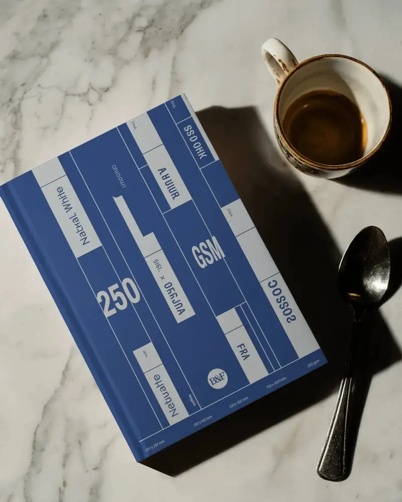 Top Down Book Mockup On White Marble Surface With Empty Espresso Cup And Spoon