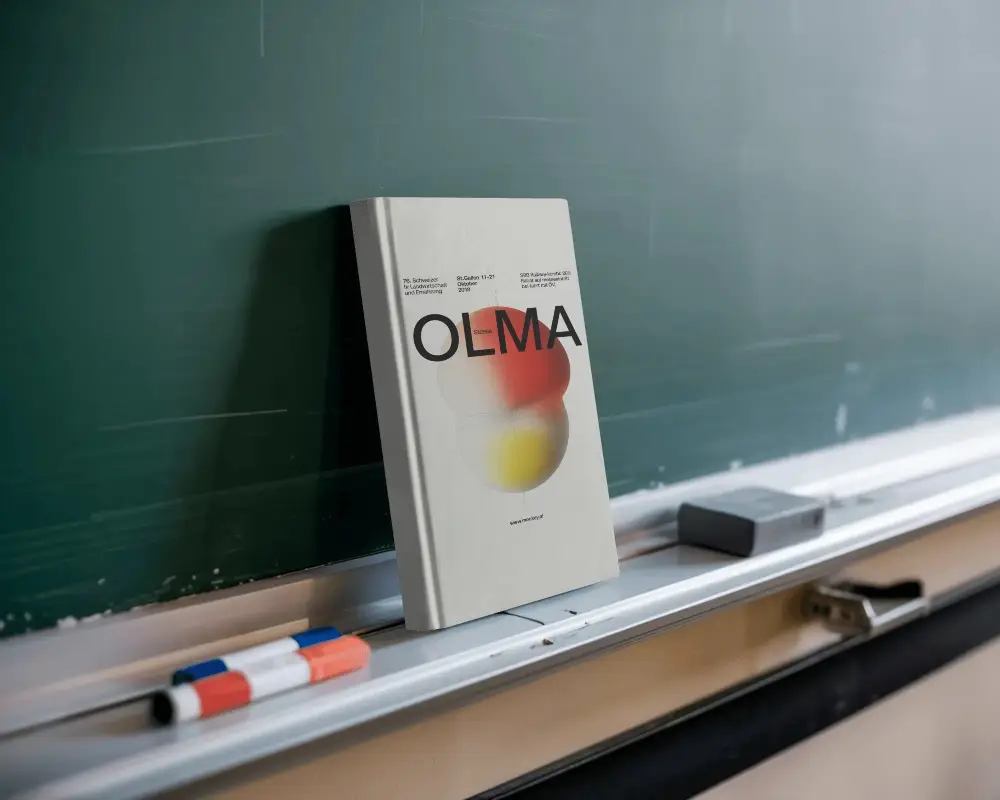 Leaning Book Mockup Against Board Tray With Markers And Eraser In Classroom Setting