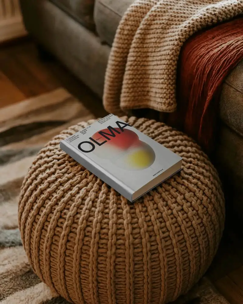 hardcover-book-mockup-on-knit-pouf-living-room-cozy-reading-space-decoration