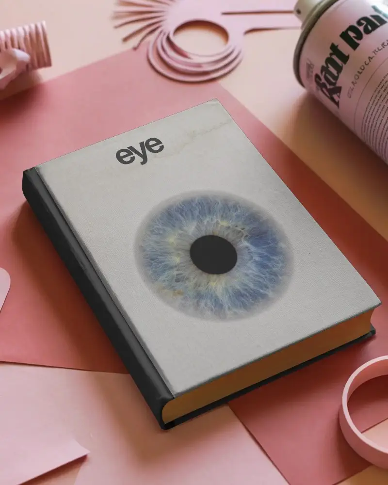 Hardcover Book Mockup Laying On Matte Surface With Art Supplies Around