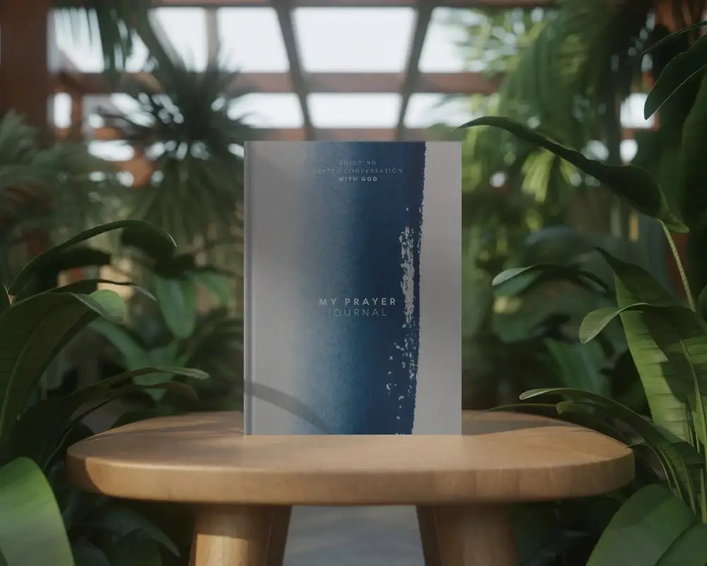 Minimalistic Hardcover Book Mockup Placed On Round Wooden Table With Lush Greenery