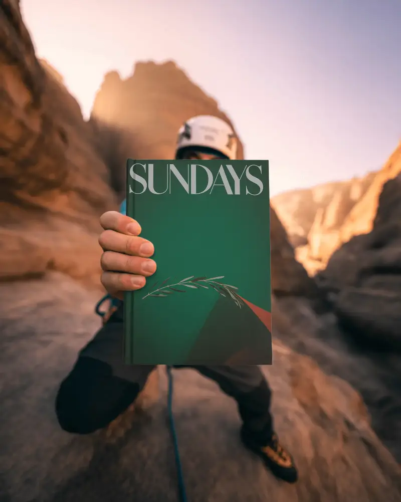 Adventure Themed Book Mockup Held By Climber In Rocky Mountain Landscape Outdoor
