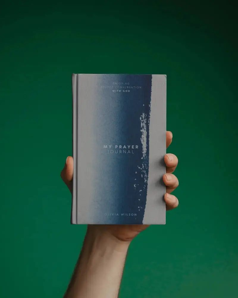 Modern Hand Held Cover Book Mockup On Solid Green Backdrop Product Display