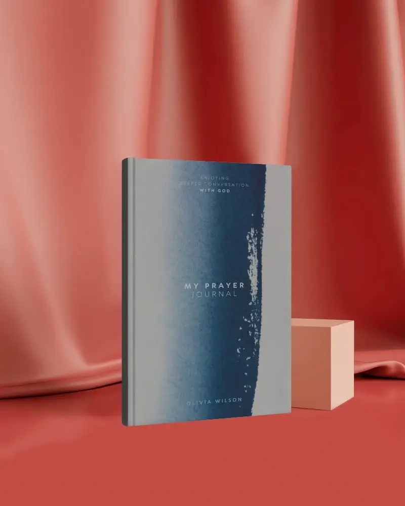 Hardcover Book Mockup Standing In Front Of Soft Red Satin Drapery With Minimal Cube Prop Studio