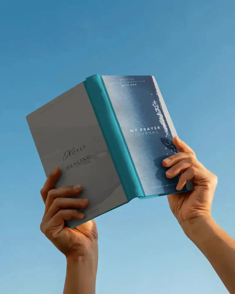 Hands Holding Hardcover Book Aloft Against Clear Sky Blank Cover Mockup