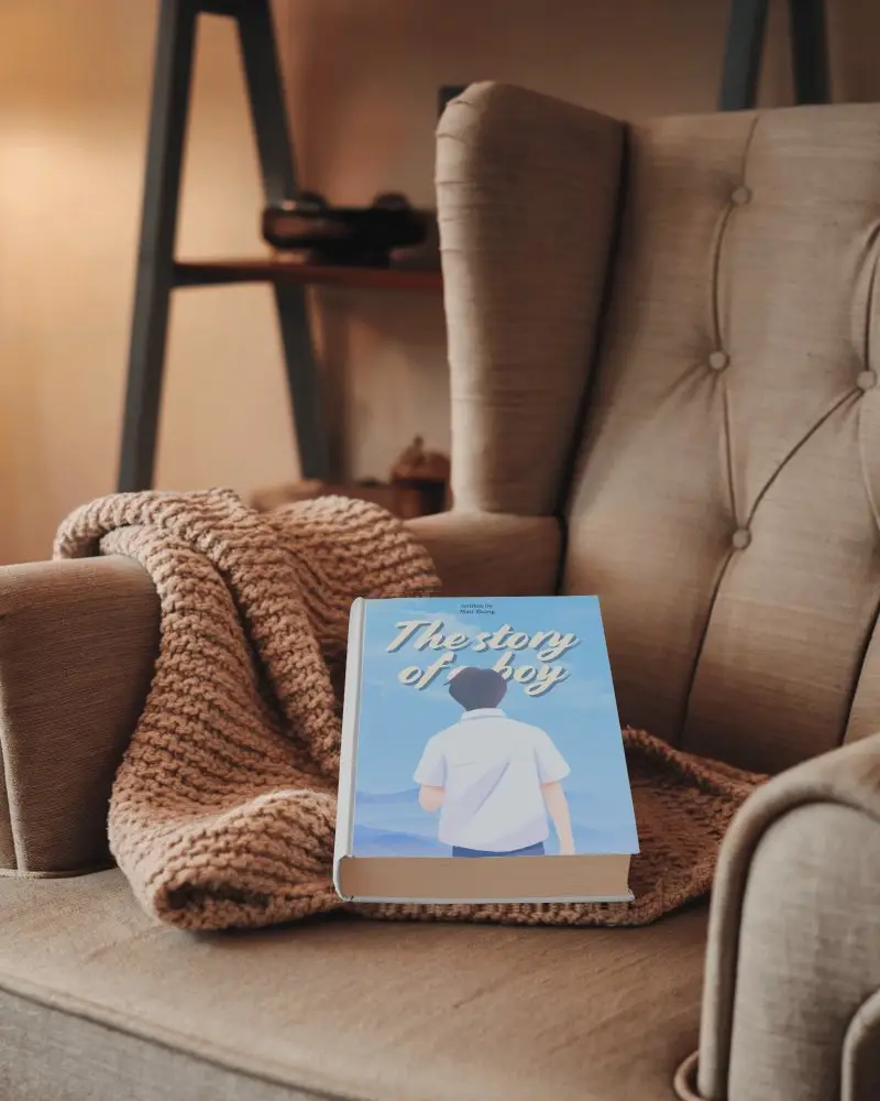 Warm And Comforting Book Mockup Hardcover On Tufted Chair With Chunky Knit Throw And Soft Glowing Light 0140