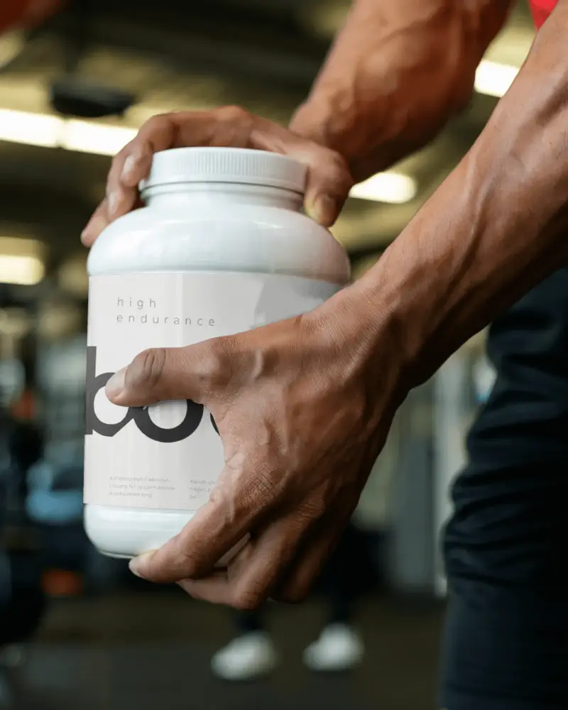 Fitness Supplement Bottle Mockup With Closeup Muscular Arms And Blank Label Design Ready