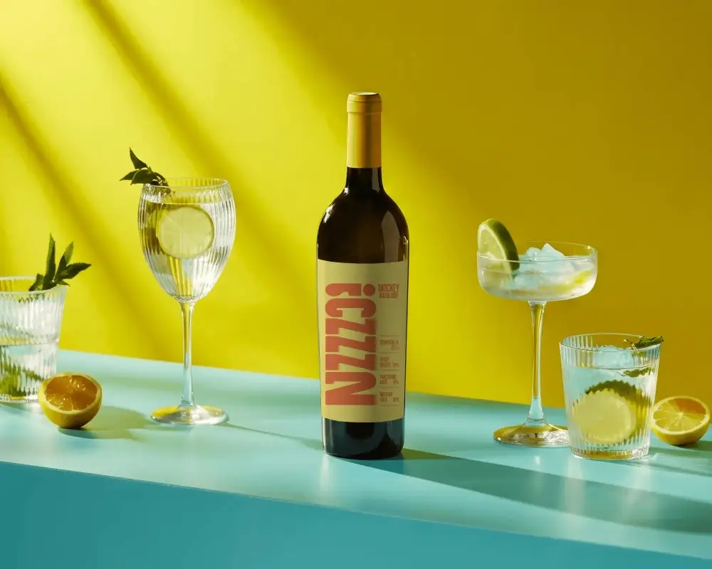 Elegant Bottle Mockup With Glasses Of Citrus Infused Drinks On A Modern Surface Setup