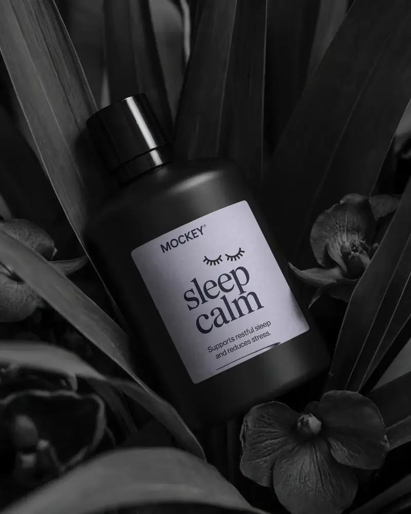 Sleek Cylindrical Bottle Mockup Surrounded By Organic Leaf And Floral Arrangement