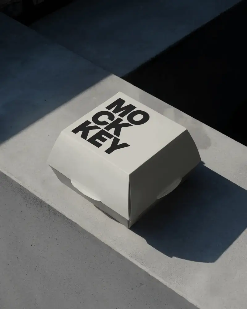 matte-burger-box-mockup-on-concrete-surface-with-dark-shadows-urban-modern-presentation