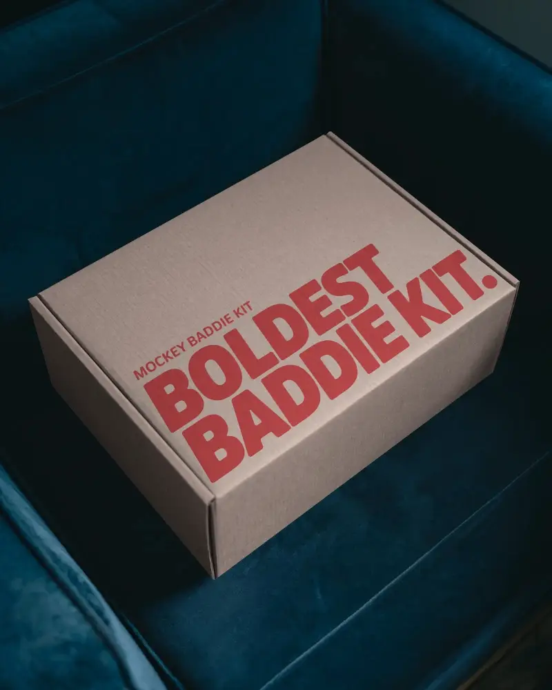 Minimal Cardboard Box Mockup On Navy Blue Sofa With Stylish Lighting For Modern Packaging