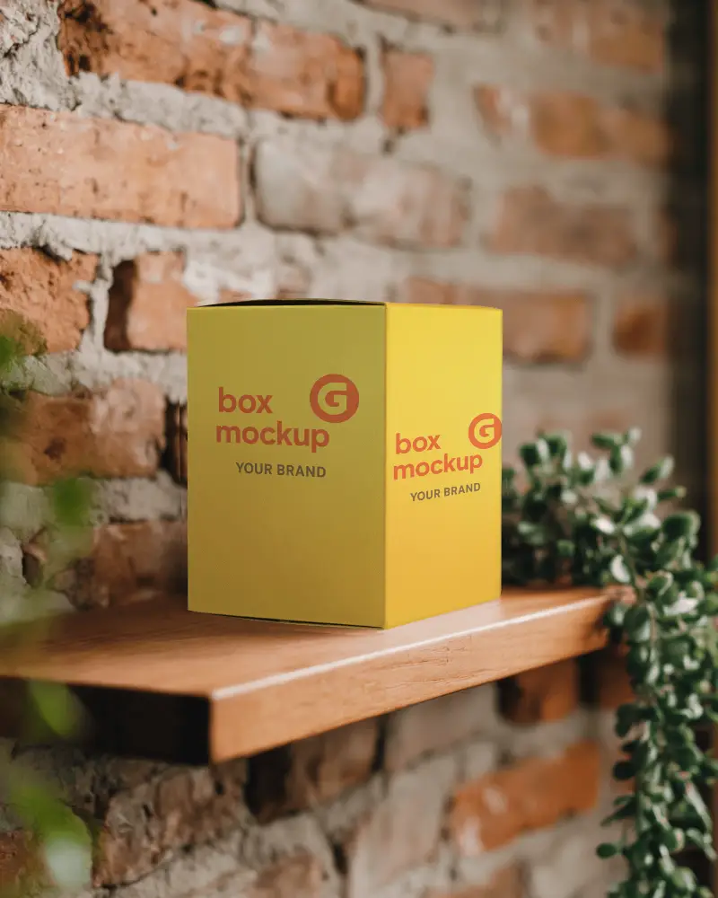 Rustic Brick Wall Box Mockup White Cardboard Box On Wooden Shelf With Greenery And Textured Exposed Brick Background 0123