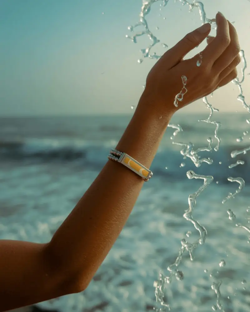 Sunlit Silver Bracelet Mockup On Wrist With Ocean Waves And Splashing Water