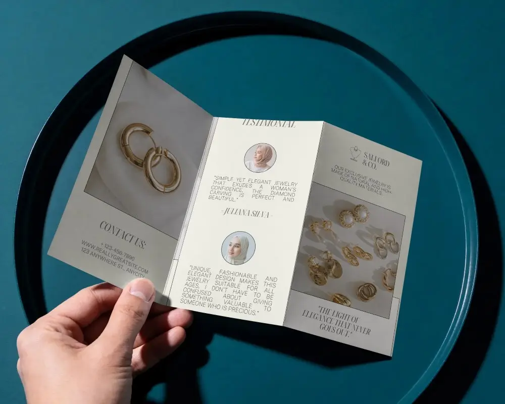 Hand Holding Trifold Brochure On Round Surface For Corporate Marketing Presentations