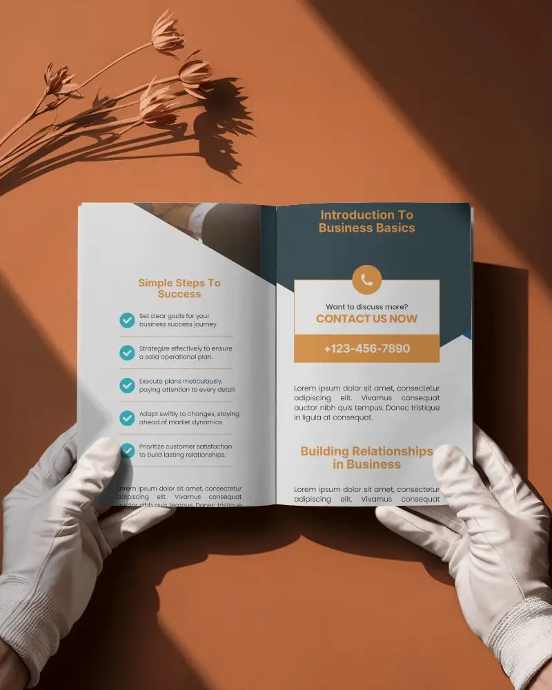 Open Bifold Brochure Mockup On Orange Surface With White Gloved Hands And Dried Flower Shadow Business Layout Perspective View