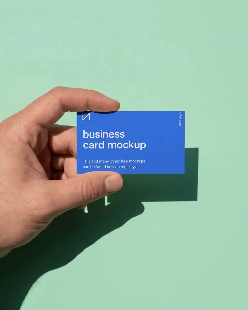 Hand Holding Business Card Mockup On Flat Surface With Shadow For Mockup Presentation