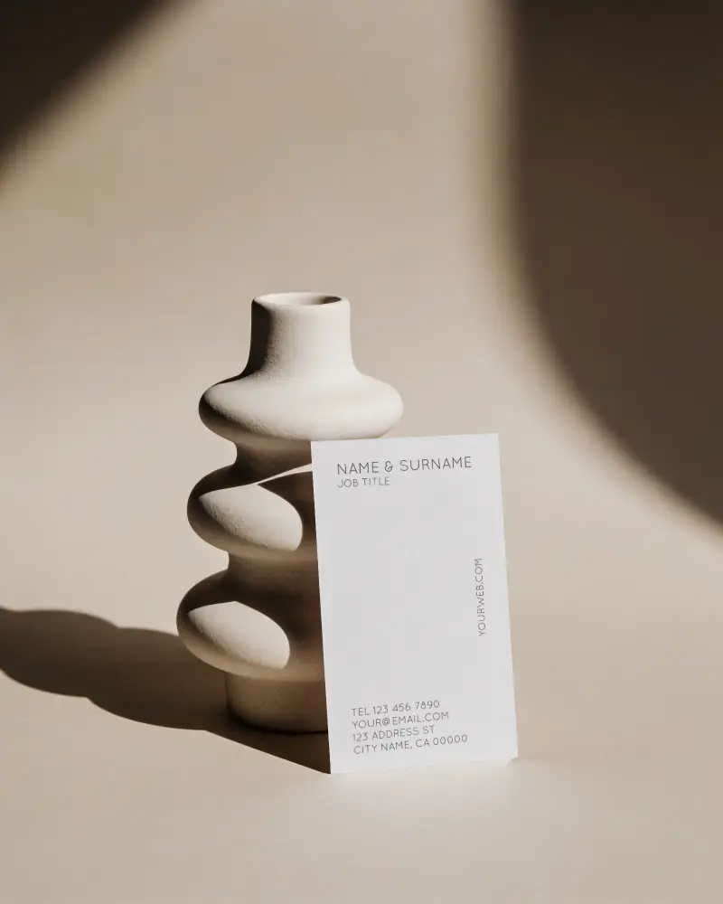 Creative Business Card Mockup Standing Upright Against Artistic Vase In Directional Soft Light