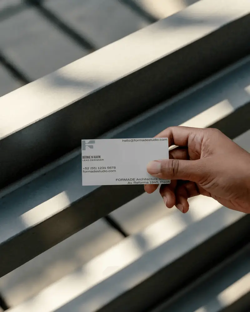 Blank Business Card In Hand Over Focused Metal Surface For Creative Design Showcase