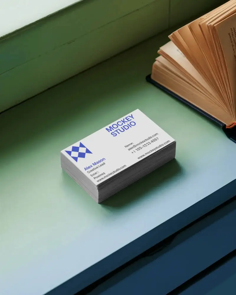 high-quality-business-card-stack-display-on-flat-surface-near-opened-classic-book