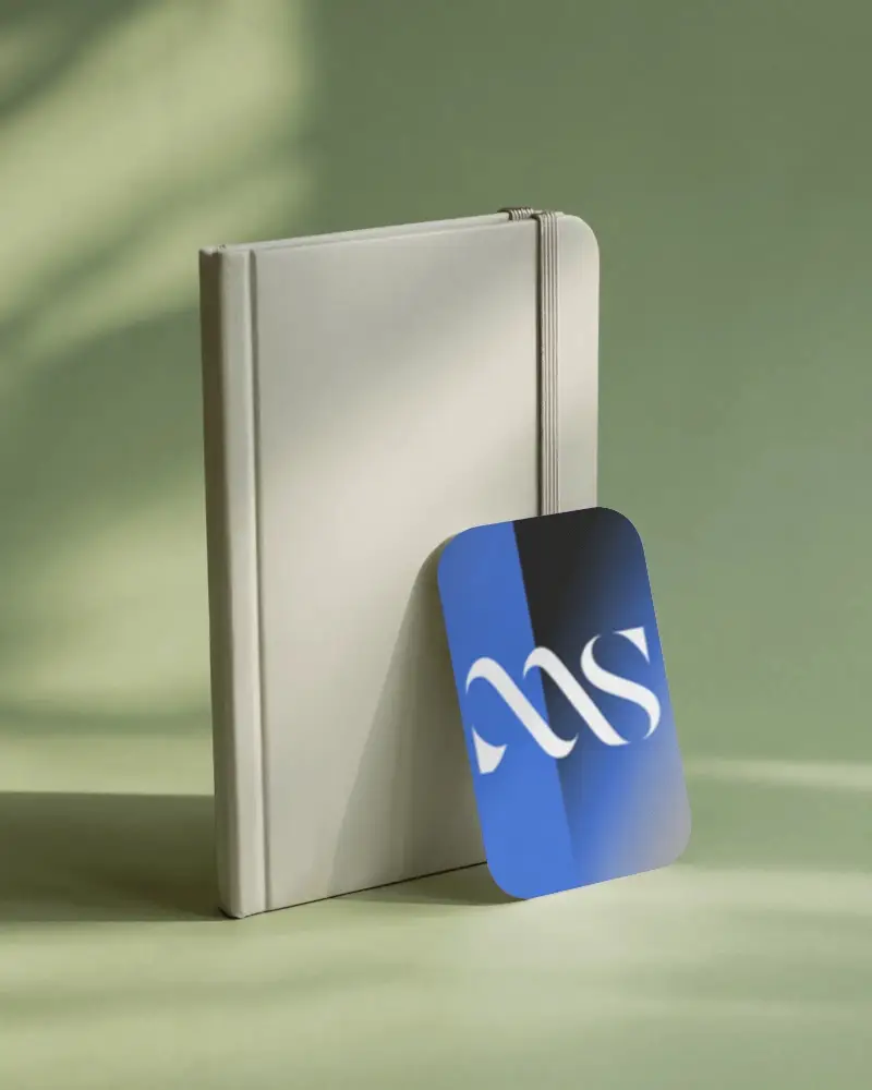 modern-corporate-business-card-mockup-standing-next-to-elastic-notebook-props