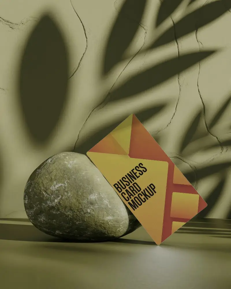 Tilted Black Business Card Mockup Leaning On Stone Rock In Nature Themed Shadowed Background
