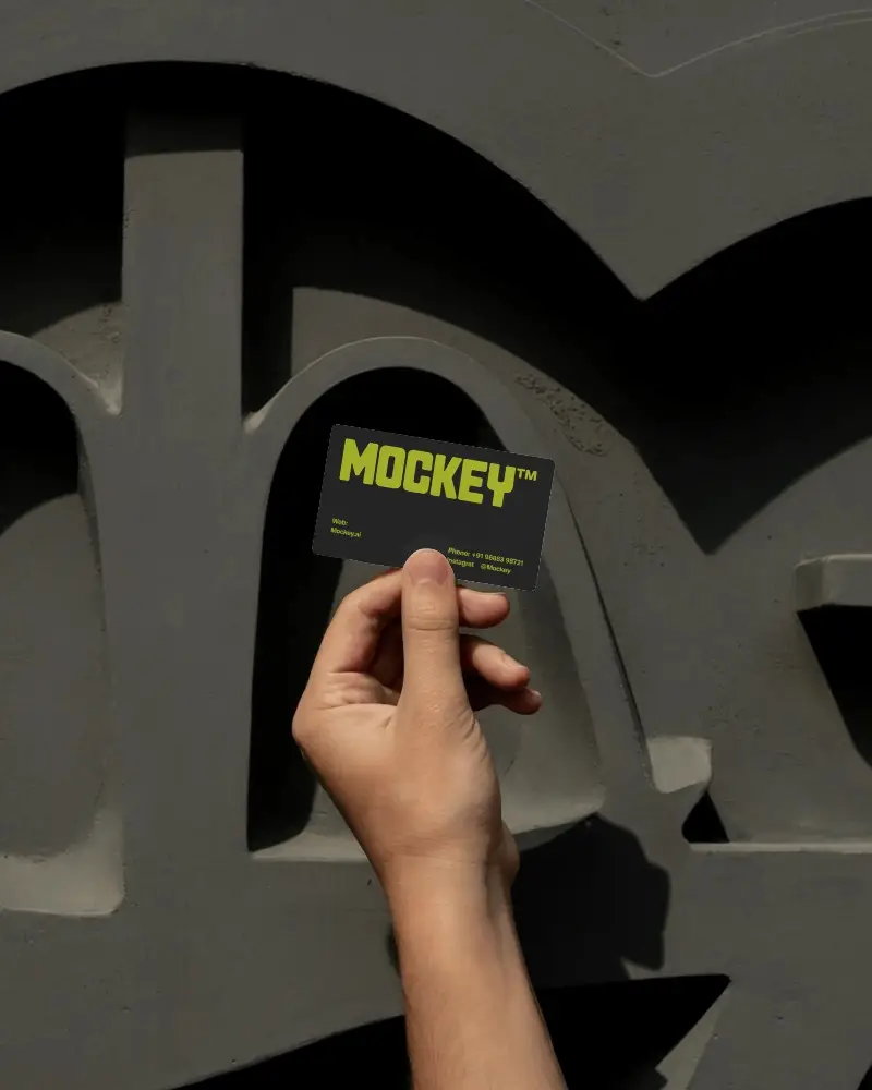 Hand Holding Business Card Mockup Against Architectural Wall With Modern Style