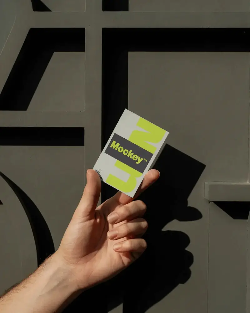 Hand Holding Business Card Mockup Against Textured Stone Wall Clean Modern Look
