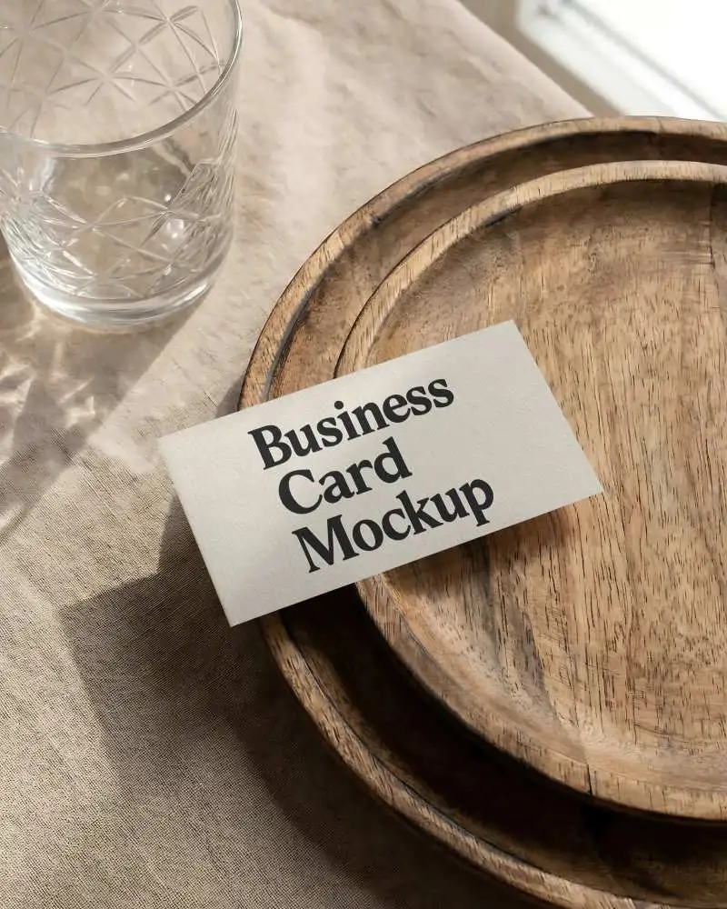 Minimalist Business Card Mockup On Textured Table With Wooden Plates And Glass